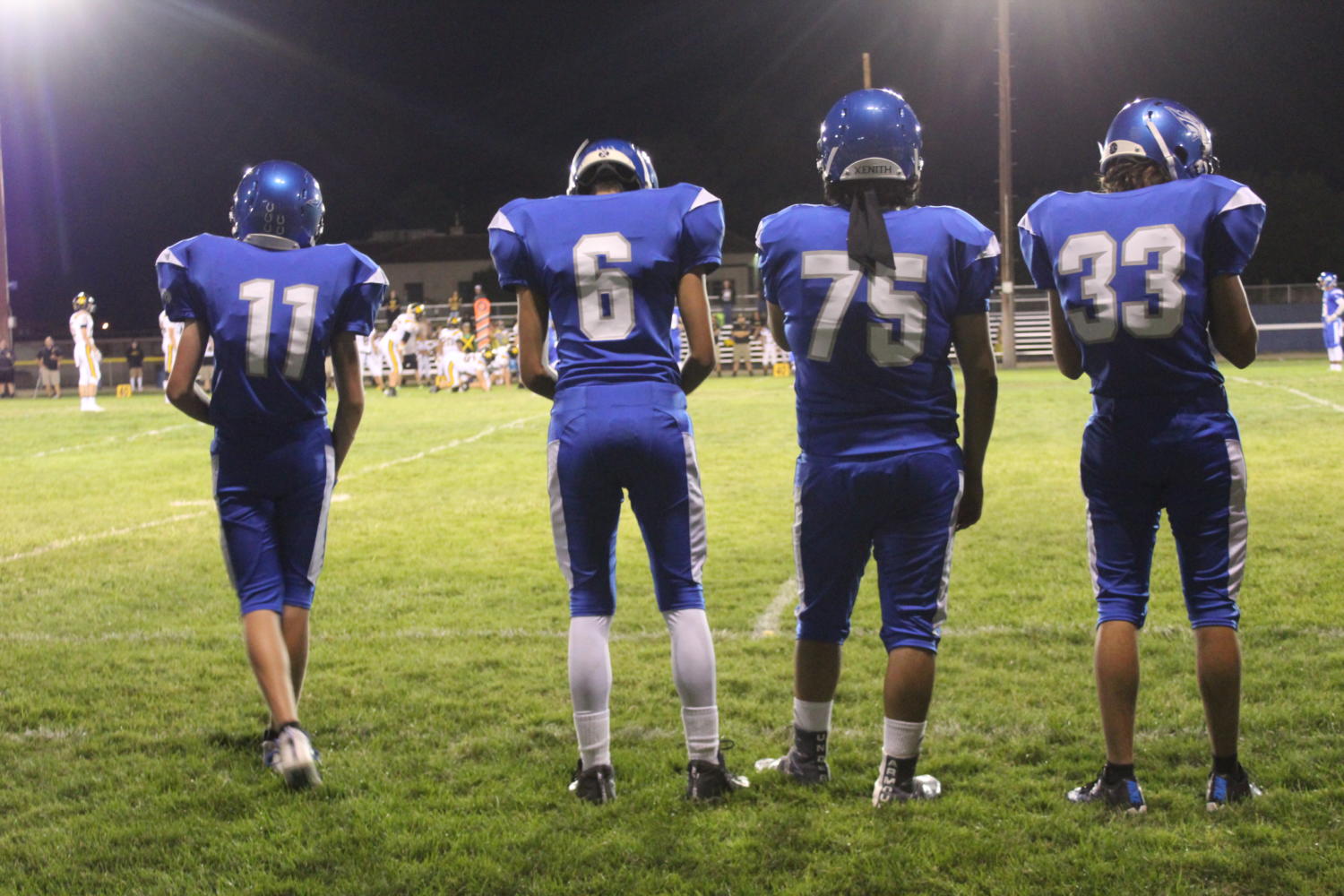 Three football players observe the game (Left to Right: Brady Womack, Josh Arnol, Sebass, Jon Tait) 