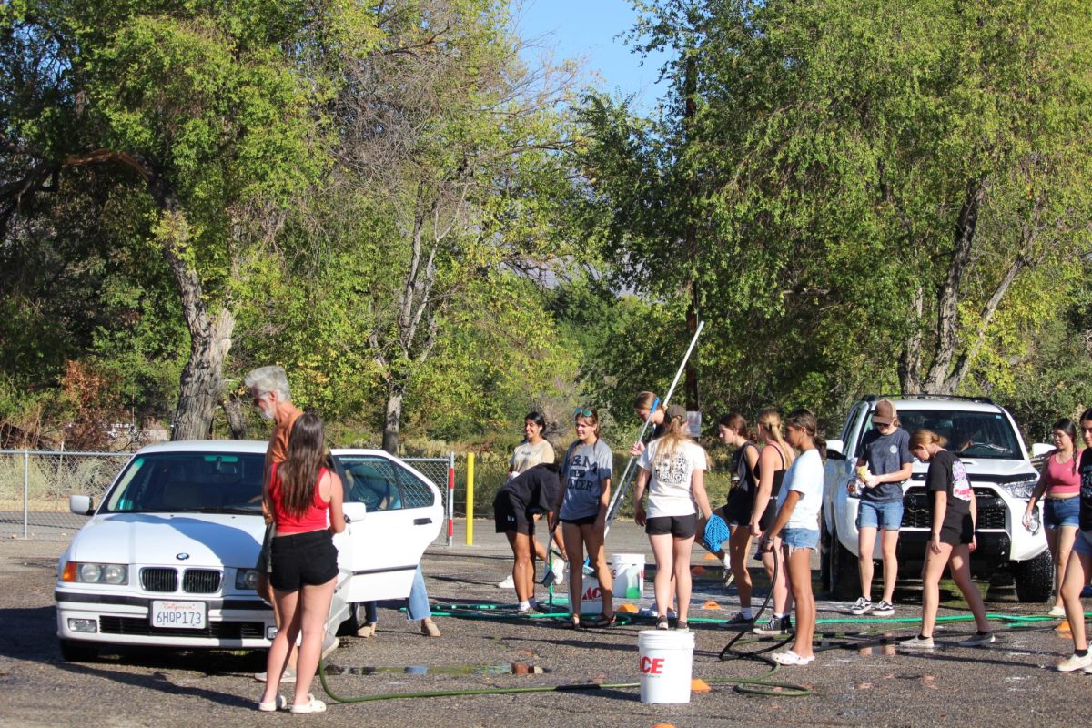 Lady soccer players washing cars 